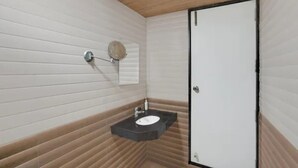 Un baño con lavamanos blanco, un espejo y una puerta.