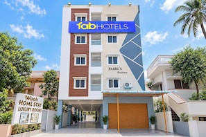 A multi-story building with a sign for 'fab hotels' and 'Pabbu's Residence.'