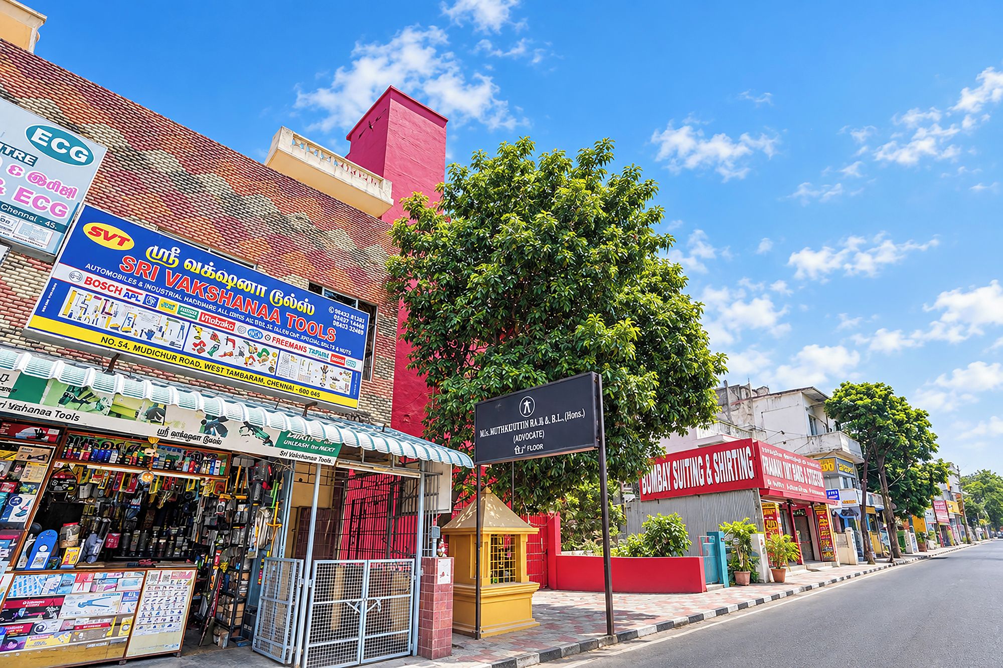 Vista de la calle con varios comercios, incluyendo una ferretería y una tienda de ropa.