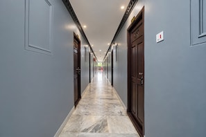 Un pasillo largo y estrecho con puertas a ambos lados, que conduce a habitaciones individuales.