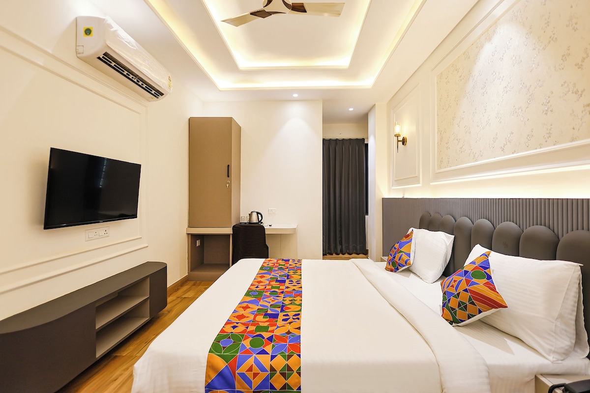 Habitación de hotel con cama, televisor, aire acondicionado y escritorio.