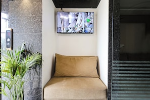 Una habitación con una cama, un televisor de pared y una planta en maceta.
