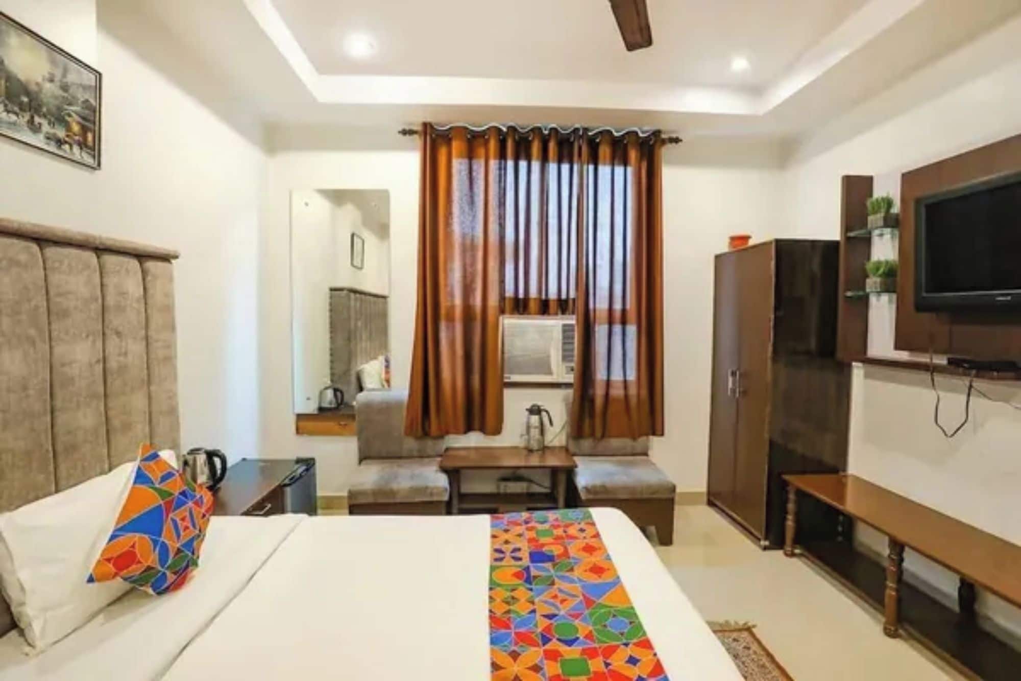 Una habitación de hotel con cama, sofá, televisión y armario.