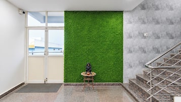 Een kamer met een groene wand, een klein tafeltje met spullen en een trap.