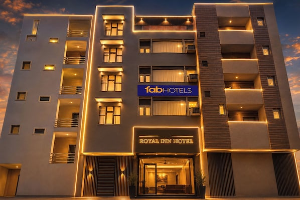 Un hotel de varios pisos con fachada moderna, balcones y un letrero destacado que dice 'fabHOTELS'.