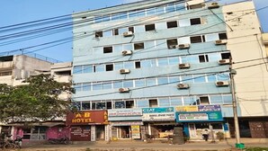 Un edificio de varios pisos con varios establecimientos comerciales en la planta baja, incluyendo un hotel y una tienda llamada CEAT.