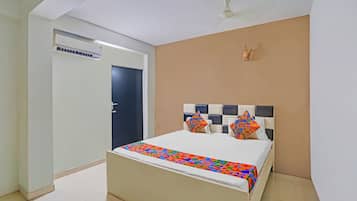 A bedroom with a bed, a ceiling fan, and a door.