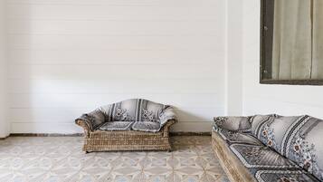 Una habitación de esquina con piso estampado, un sofá y una silla.