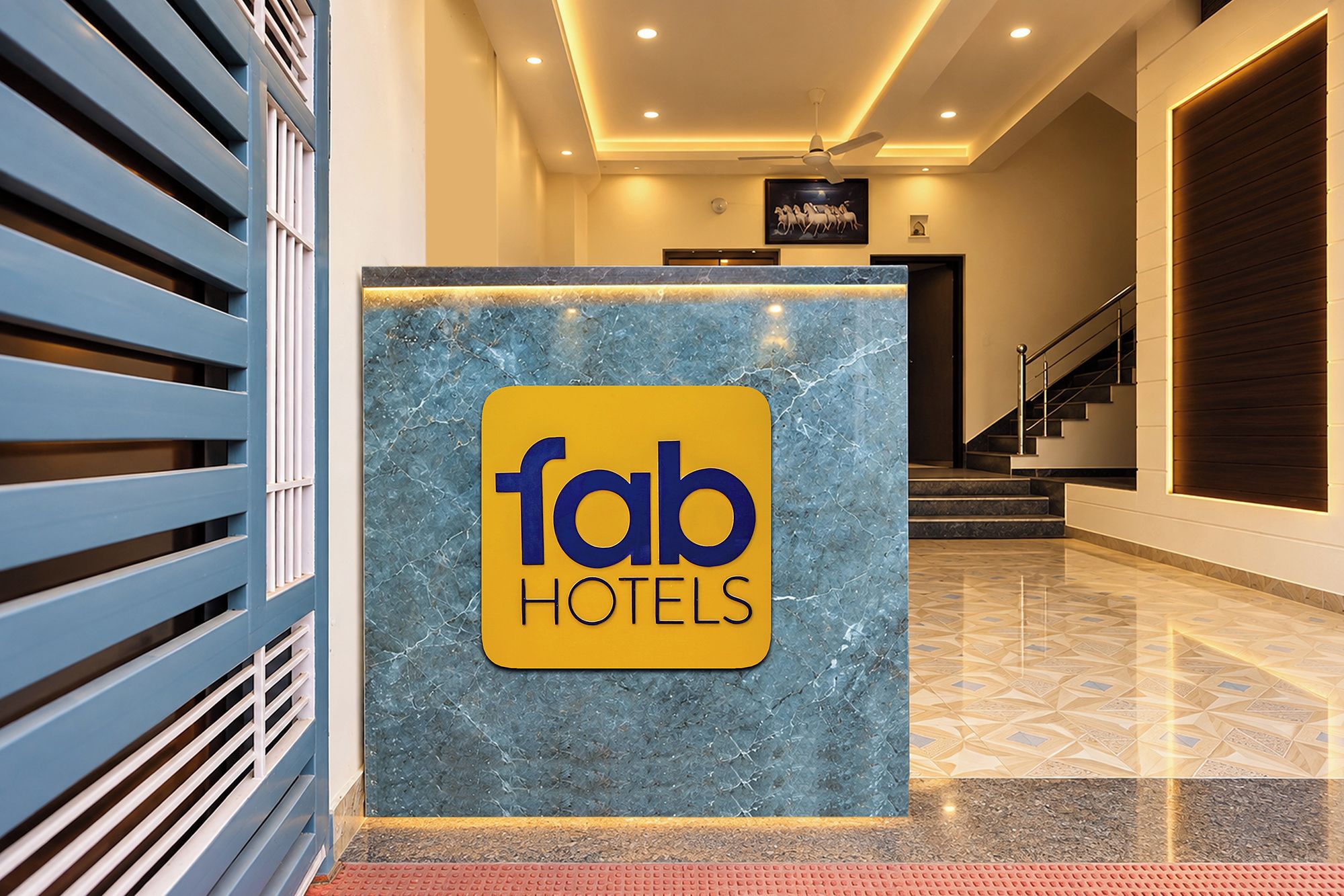 Una recepción con encimera de mármol y un cartel de Fab Hotels.