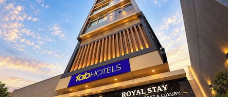 Edificio di un hotel con una segnaletica ben visibile per 'fab hotels' e 'royal stay', che sottolinea il comfort e il lusso.