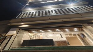 Un edificio con vestíbulo cubierto, escaleras y techo plano.