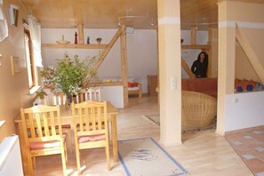 Ein gemütliches Zimmer mit einem Holztisch, Stühlen und einem gewebten Korb.