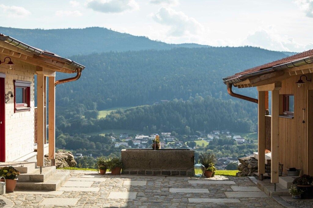 Un chemin de pierre mène à un bâtiment d’où l’on a vue sur une vallée et des montagnes.