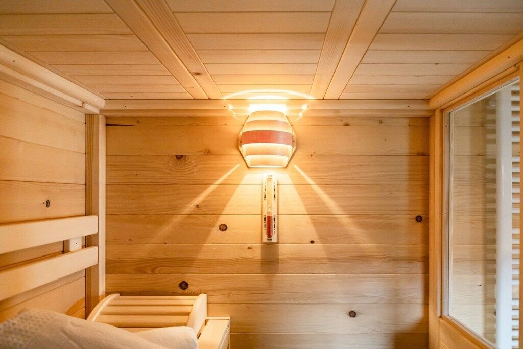 Un sauna avec des murs en bois, un banc et un radiateur fixé au mur.