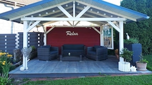 A covered patio area with a red wall and the word 'Relax' on it. - Holiday apartment in Vöhl with swimming pool (Vöhl)