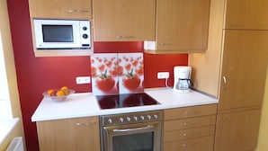 A kitchen with a microwave, stove, oven, and a coffee maker on the countertop. - Holiday apartment in Vöhl with swimming pool (Vöhl)