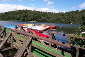 A dock with boats, a forested shoreline, and a clear sky. - Gingerbread House Gretel (Frankenau)