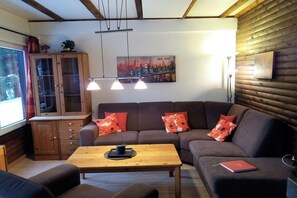 Ein gemütliches Wohnzimmer mit einer Couch, einem Holztisch und einem Schrank.