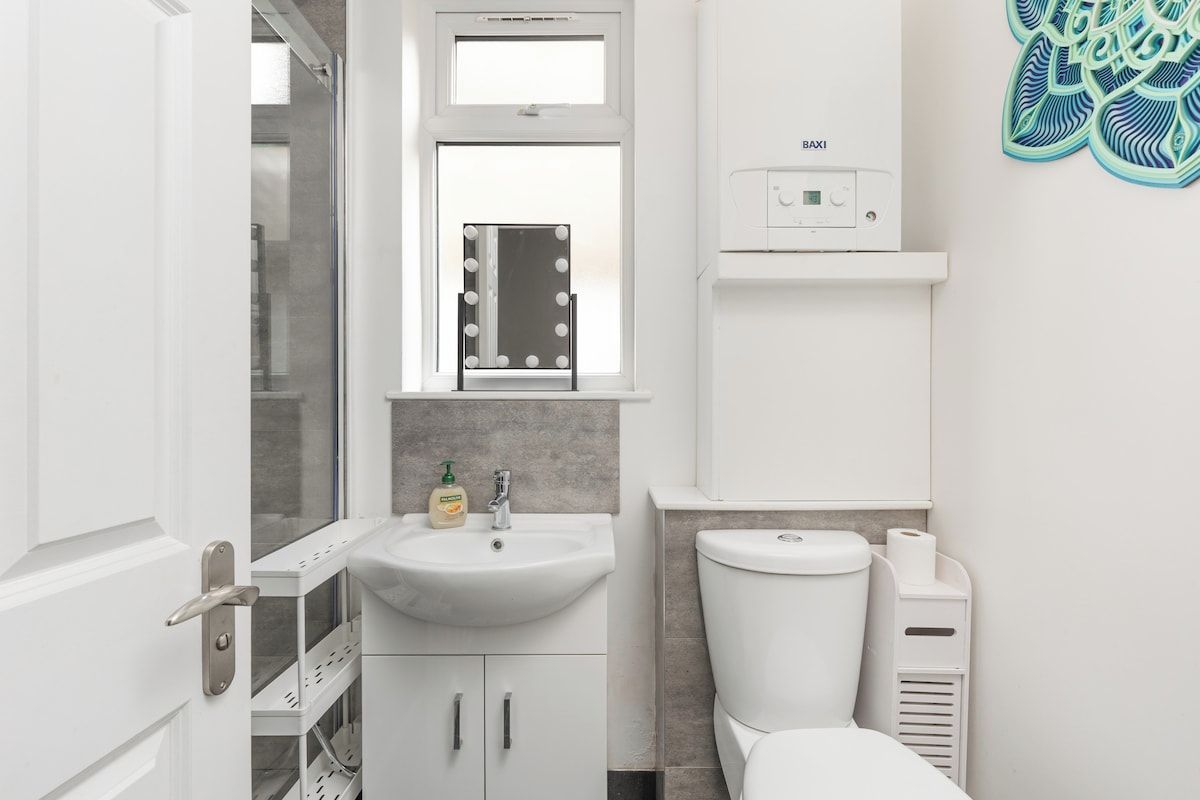 Ein Badezimmer mit Waschbecken, Waschtisch, Spiegel und Toilette.