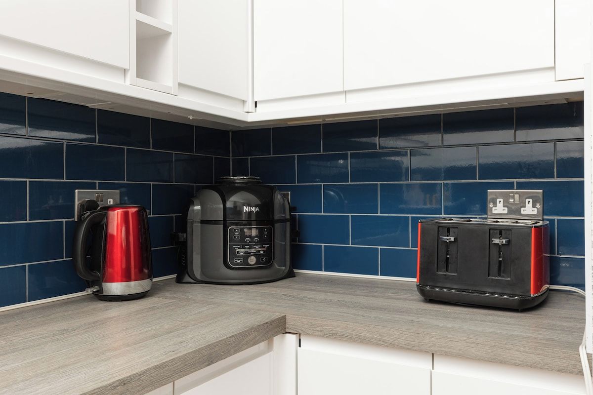 A kitchen with a coffee maker, a blender, and a toaster on the counter.