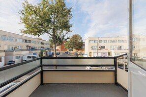 A balcony with a view of a residential street, a tree, and parked cars. - New! Spacious 4BR House w/Garden in Mitcham (Greater London)
