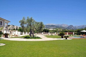 A well-maintained garden with a pool, a gazebo, and a view of mountains in the background. - Ses Rentedores [2257] (Selva)