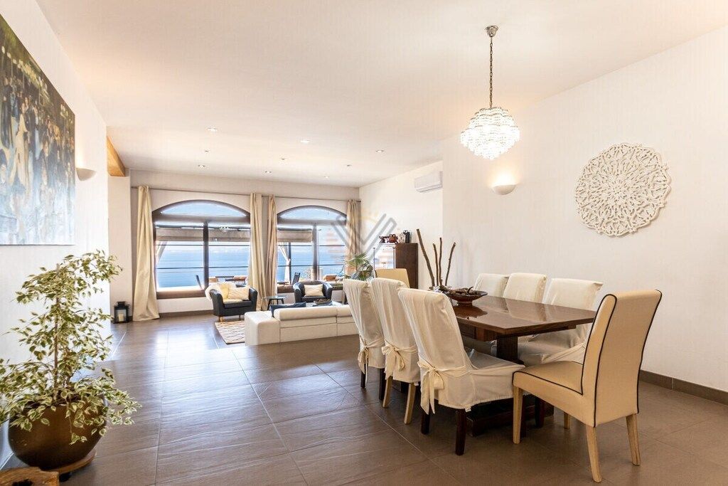 A dining area with a table, chairs, and a chandelier.