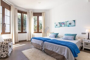 Une chambre avec deux lits, un canapé et des œuvres d’art accrochées au mur.
