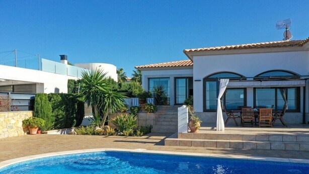 A residential property with a swimming pool, a patio with outdoor furniture, and a modern house with large windows. - SaTorre Voramar [4501A] (Sa Torre)