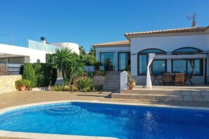 A residential property with a swimming pool, a patio with outdoor furniture, and a modern house with large windows. - SaTorre Voramar [4501A] (Sa Torre)