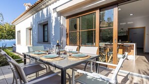 An outdoor dining area with a table set for four, overlooking a body of water. - SaTorre Voramar [4501A] (Sa Torre)
