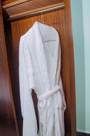 A white bathrobe hanging on a wooden door.