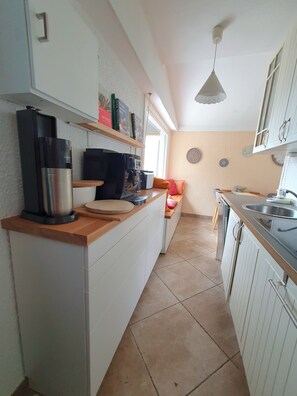 A kitchen with white cabinets, a coffee machine, a sink, and a window. - Beautiful bungalow. Swimming pool. Breathtaking views of Lake Garda and the mountains. Dogs are welcome. (Aer)
