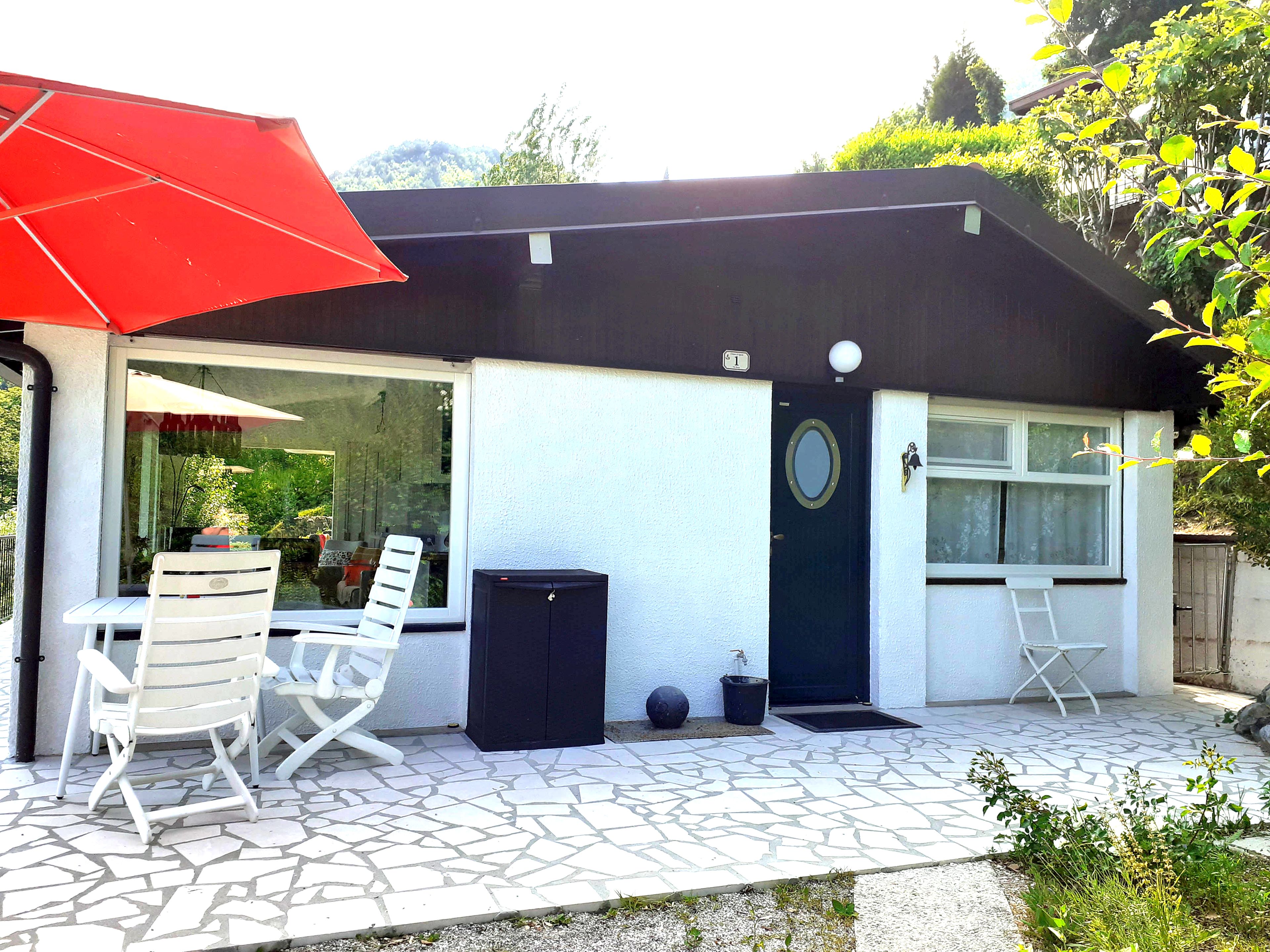 Uma casa com varanda, porta, janela e caixa de correio.