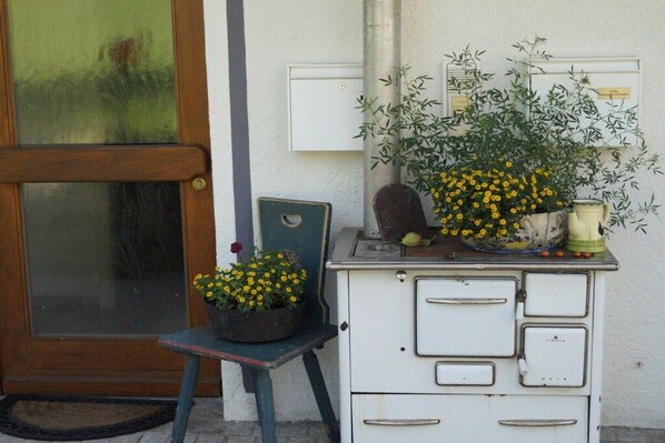 Un meuble de rangement blanc, doté de plusieurs tiroirs, et une petite table sur laquelle est posée une plante en pot.