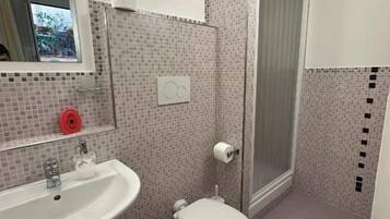 Ein Badezimmer mit Waschbecken, Toilette und Dusche.