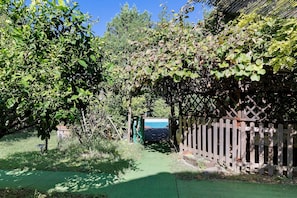 A garden with a wooden fence, a green pathway, and a pool area. - Casa Vacanze Le Camelie with Private Pool, Wi-Fi, and Air Conditioning (Vecchiano)