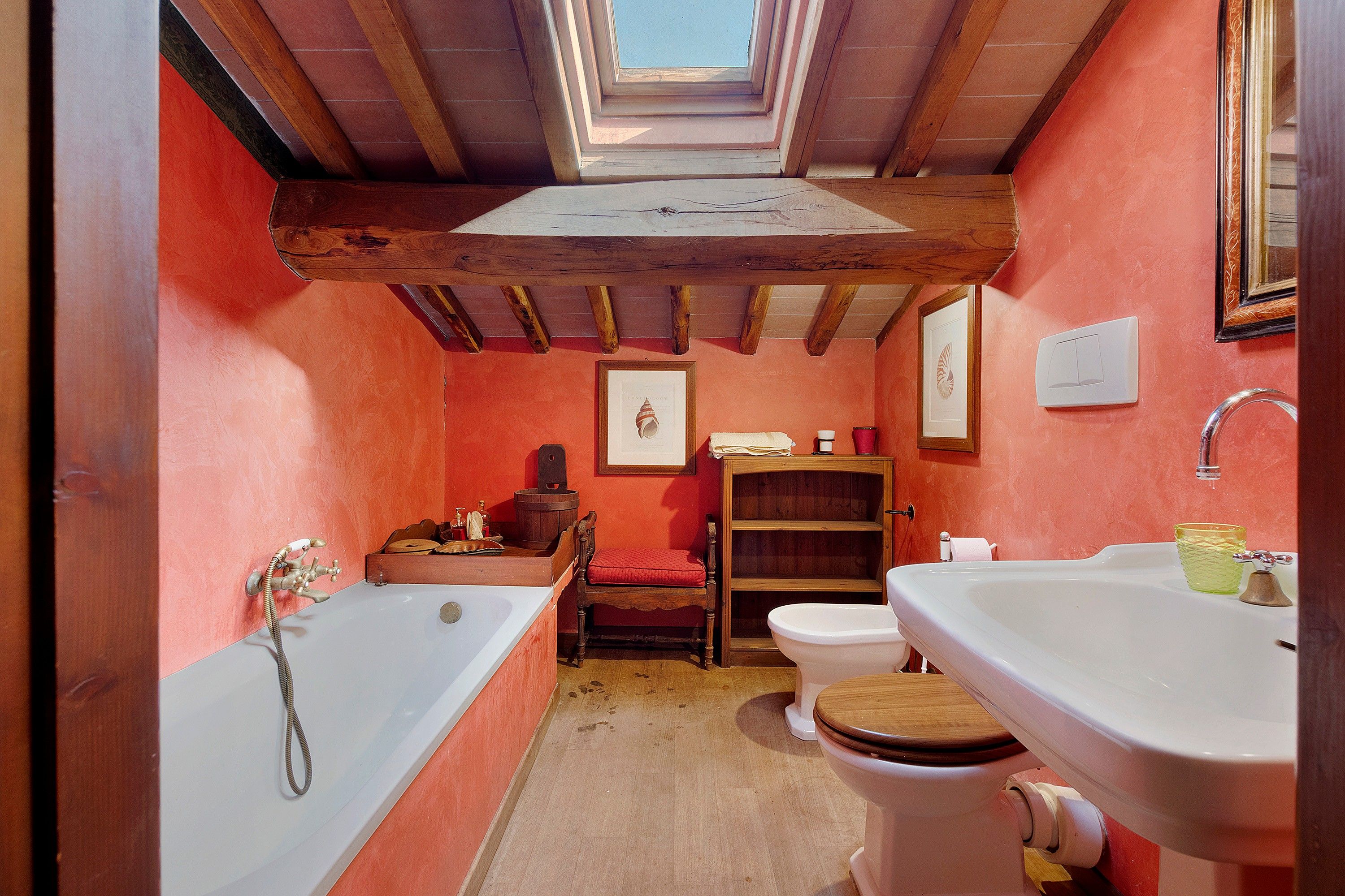Une petite salle de bain dotée d’un puits de lumière, d’une baignoire, de toilettes et d’un lavabo.
