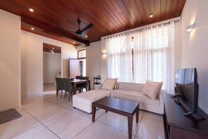 A modern living room with a sectional sofa, a coffee table, and a TV. - Garden Villa for 10 people with 5 Spacious Bedrooms - Heart of Colombo (Colombo)
