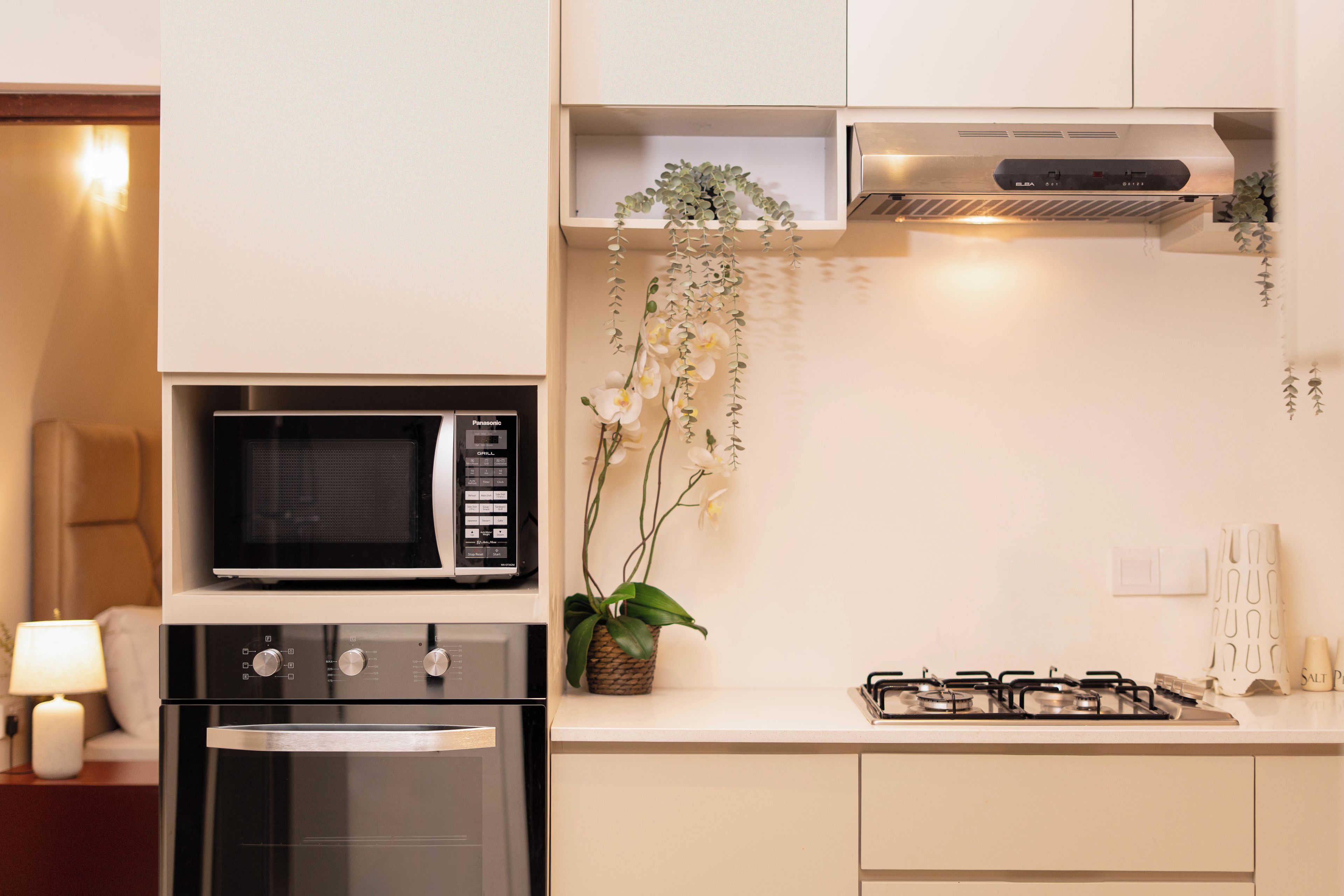 A modern kitchen with a built-in microwave, oven, and gas stove.