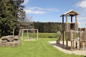 A playground with a swing set and a wooden play structure. - Black Forest Lounge Holiday Home Lindenbuch (Loßburg)
