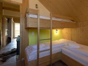 A bunk bed room with a wooden ladder, a green wall, and a small window. - One-bedroom Cabin (Sankt Georgen am Kreischberg)