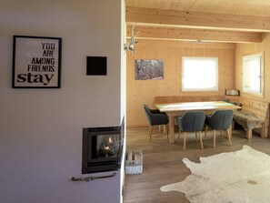 Ein gemütliches Blockhaus-Interieur mit Essbereich, Kamin und einer an der Wand befestigten Schilder.