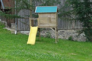 A wooden structure with a blue roof, possibly a birdhouse or a small shelter, and a yellow slide attached to it. - Holiday apartment in Böbrach with Wi-Fi (Böbrach)