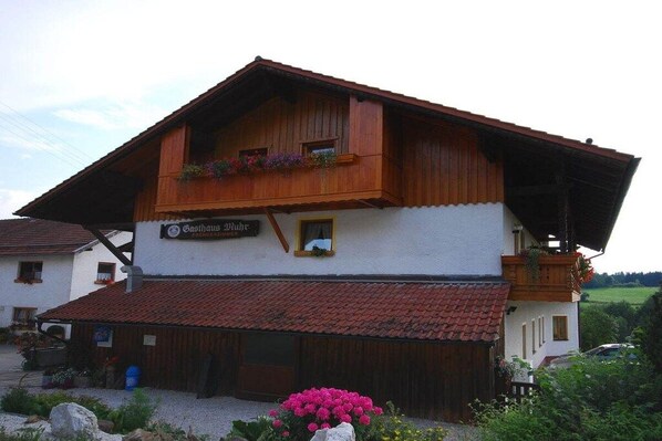 A traditional chalet-style building with a sloped roof, wooden balconies, and a sign indicating it is a guesthouse. - Holiday apartment in Böbrach with Wi-Fi (Böbrach)