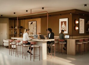 Uma área de bar moderna com balcão central, vários bancos e quadros nas paredes.