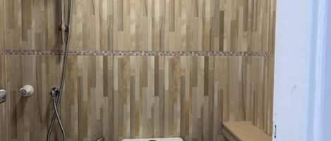 A small bathroom with a toilet, a shower, and a sink.