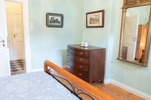 A bedroom with a bed, dresser, two framed pictures, and a mirror. - Manor House Burg Vlatten - To the Court (Heimbach)