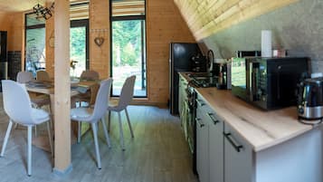 A modern kitchen with wooden cabinetry and a dining area with white chairs.