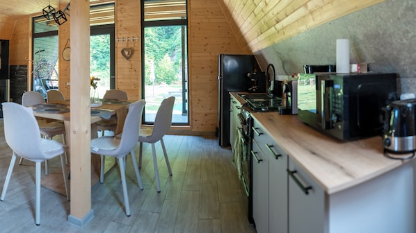 A modern kitchen with wooden cabinetry and a dining area with white chairs.
